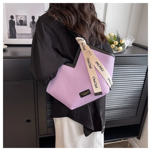 Détail du sac cabas plissé lavande avec logo de mode et poignée en ruban