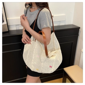 Detail of white crochet tote bag with colorful bows and brown leather straps