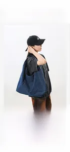Detail of a large capacity washed denim shoulder bag with metal zipper and retro aesthetic