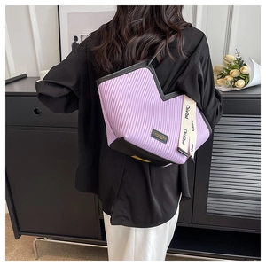 Détail d'un sac cabas plissé violet avec ouverture en V et bandoulière tissée