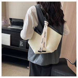 Détail du sac cabas plissé avec bordure noire et large bandoulière en toile avec logo