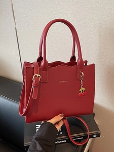 Elegant red bridal tote bag with wavy edges and cherry pendant shown in lifestyle setting