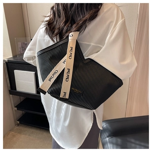 Détail du sac cabas plissé noir avec bandoulière large stylée et design moderne