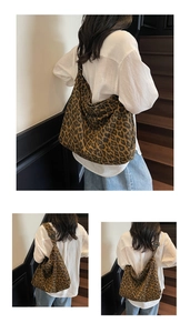 Detailed view of a large leopard print tote bag styled with a minimalist white shirt outfit