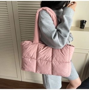 Close-up of pink quilted puffer tote bag shown with a gray casual outfit for daily commute