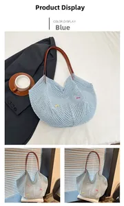 Detail of light blue woven tote bag with colorful butterfly embroidery and brown straps