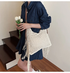 Detail of hand-woven hollow wax rope tote bag with side fringe and brown leather strap