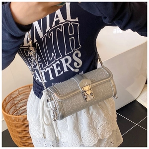 Mirror selfie showing a silver sequin cylinder bag with chain strap and metal clasp