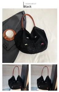 Detail of black crochet tote bag with colorful butterfly embroidery and leather straps