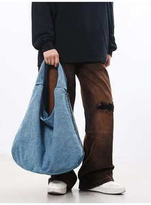 Detail of light blue washed denim tote bag with side hidden zipper and spacious design