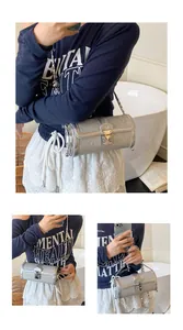 Detail of silver sequin cylinder bag with M-logo metal clasp and chain strap