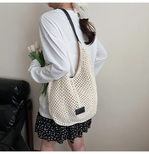 Détail du sac à bandoulière en paille tressée ajourée avec sangle en cuir noir