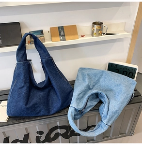 Close-up of light and dark blue denim tote bags with sturdy straps and metal zippers