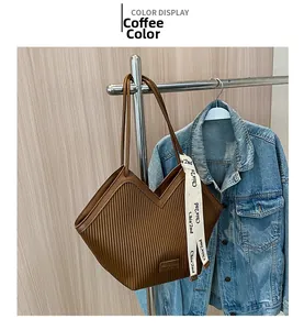 Détail du sac cabas plissé marron café avec texture verticale et ruban décoratif
