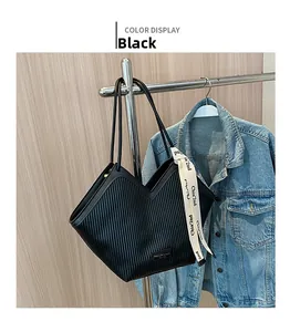 Gros plan sur le sac fourre-tout plissé noir avec ouverture en V et ruban déco