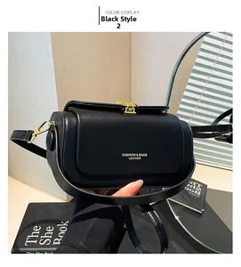 Detail of black leather box bag with gold metal clasp and mirror reflection display