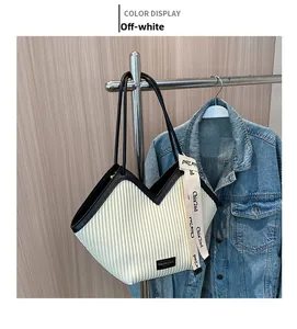 Détail du sac cabas blanc cassé avec ouverture en V, texture plissée et finitions en cuir noir