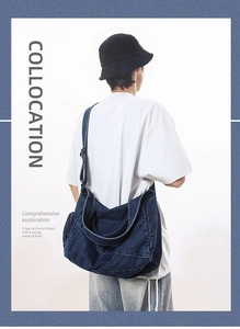 Detailed back view of a dark blue washed denim messenger bag on a male model outfit
