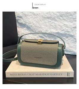 Close-up of green woven texture flap with golden shell buckle on small square box bag