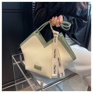 Détail du sac cabas plissé crème avec garniture vert sauge et ruban sur l'anse
