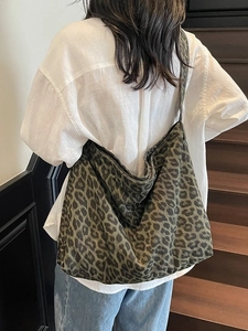 Large vintage green leopard print canvas tote bag shown worn by a model in casual style