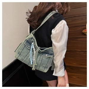Détails d'un sac cabas en denim vintage avec boutons en métal et breloque à franges