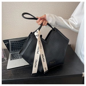 Détail du sac à bandoulière noir plissé avec ruban logo et texture en cuir élégante