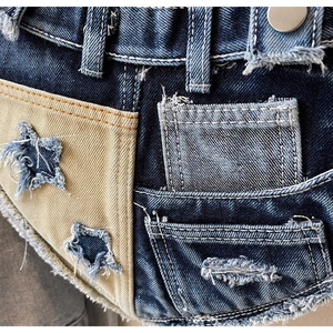 Detailansicht der Denim-Patchwork mit khakifarbenem Stern und distressed Fransen