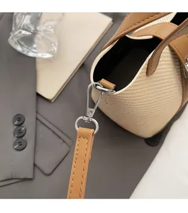 Detailed close-up of high-gloss silver hardware and brown leather trim on woven bag