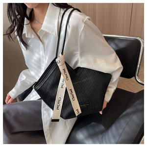 Détail du cabas noir plissé avec étiquette de mode et sangle décorative imprimée chic