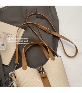 Detail of adjustable strap and straw leather patchwork on the shoulder bucket bag