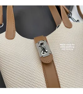 Detail of silver metal twist lock and textured woven fabric on bucket handbag