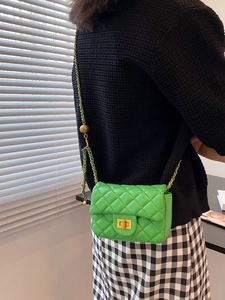 Groene mini crossbodytas met ruitvormig stiksel en kettingriem gedragen op model