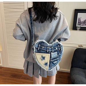 Detail einer herzförmigen Denim-Tasche mit Patchwork-Sternen und Fransenkanten
