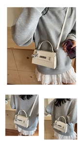 Detail of off-white leather Kelly bag featuring silver hardware and bear charm