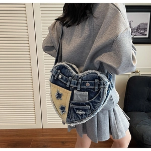 Makrodetail der herzförmigen Denim-Tasche mit Patchwork, Fransen und Stern-Ausschnitt