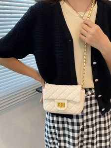 Elegante witte gewatteerde crossbodytas met gouden ketting en draaisluiting op model