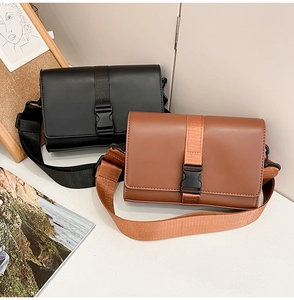 Detail of minimalist messenger box bags in black and brown with wide nylon shoulder straps