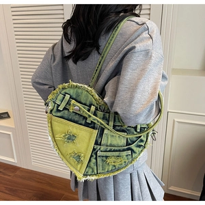 Detailaufnahme der herzförmigen Denim-Tasche mit Y2K-Stern-Patches und Fransen