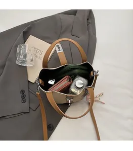 Close-up of the spacious interior of a woven contrast bucket bag with leather details