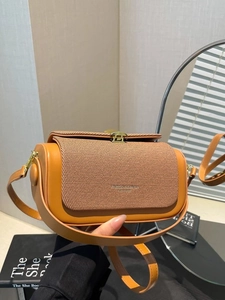 Orange tweed and leather luxury handbag with gold round lock clasp in a lifestyle setting