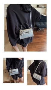 Detail of silver metallic leather handbag featuring textured finish and designer hardware