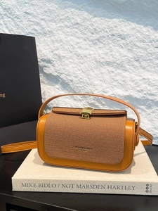 Luxe yellow and brown woven box bag with golden shell clasp on artistic books