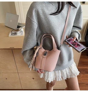 Pink woven texture bucket bag with silver metal buckle and elegant tassel charm