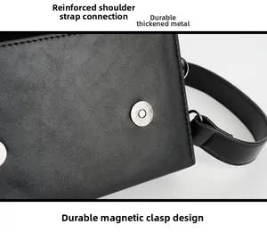 Detail view of black leather bag featuring magnetic buckle closure and metal hardware