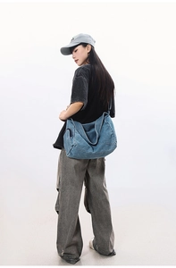 Detailed view of the washed denim crossbody bag featuring a vintage slouchy shoulder design