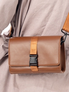 Besace en cuir PU marron avec fermeture à rabat et sangle nylon portée par un mannequin