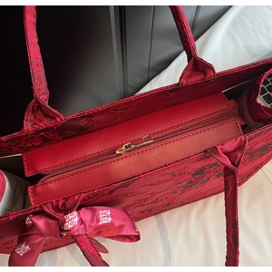 Detail of red jacquard wedding tote bag featuring side bow with double happiness symbol