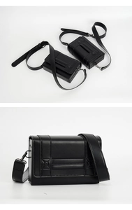 Close-up of black leather crossbody box bag showing adjustable strap and matte metal hardware