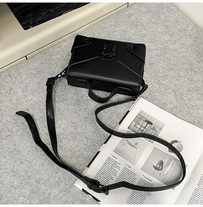 Top view of a structured black matte PU leather crossbody bag with metal lock detail